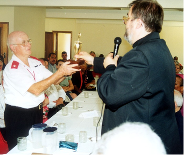 Father Gérard presenting the President’s Award trophy to Victor Claudius in 2002
